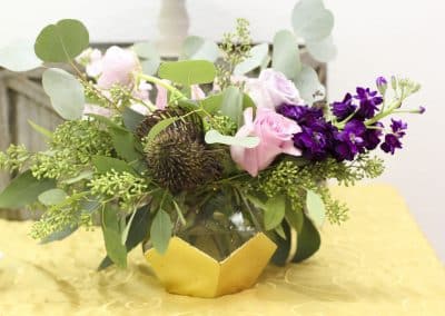 Fresh flower centerpiece with hydrangea, pink roses, and eucalyptus in a geometric vase.
