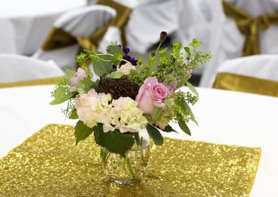 Fresh flower centerpiece with hydrangea, pink roses, and eucalyptus in a clear vase.